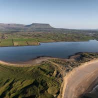 Aerial view of a beach and sea with Benbulben overlooking it