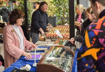 Customers looking into a cabinet displaying jewellery with a lady behind the counter