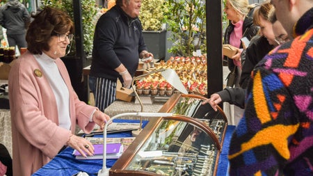 Customers looking into a cabinet displaying jewellery with a lady behind the counter
