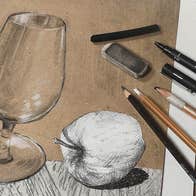 A sketch of a glass and an apple with pencils laid on it.