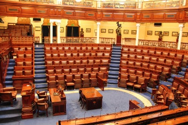 Wood and leather seats in tiers overlooking a carpeted central point with a table 