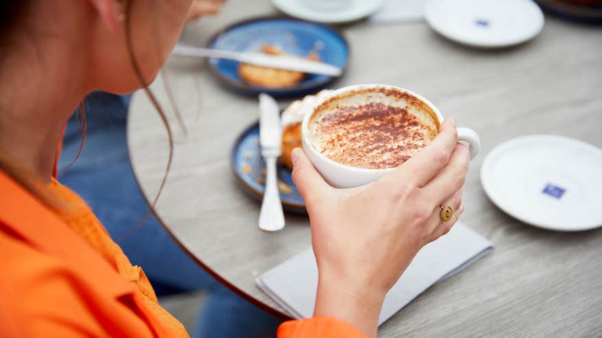 Woman drinking a cappuccino.