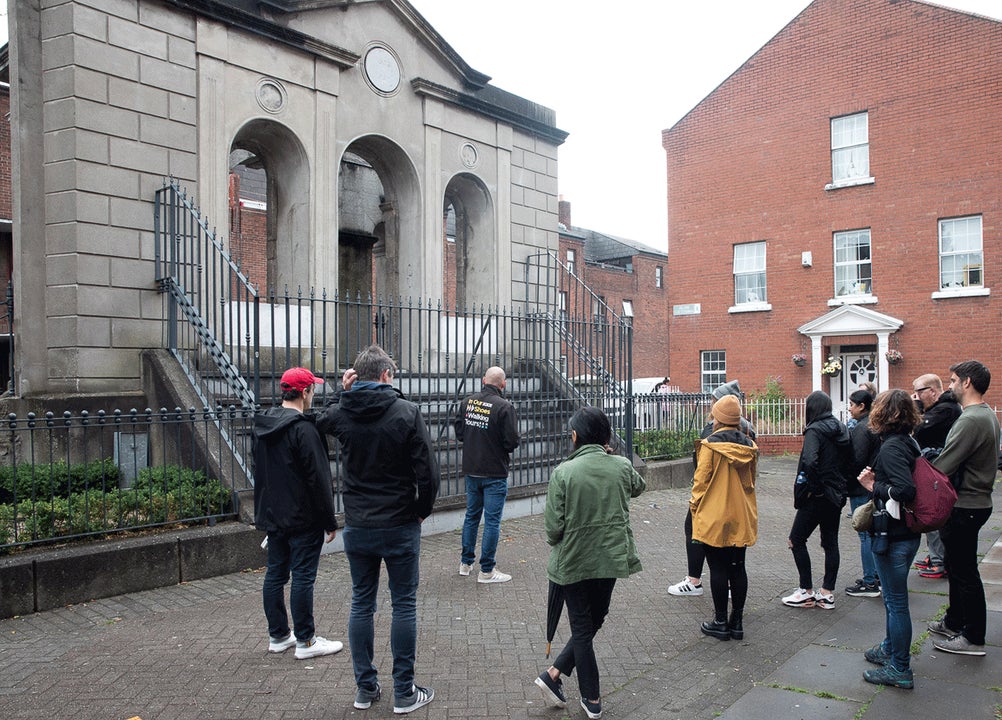 Group on a walking tour with the Coombe hospital monument in the background