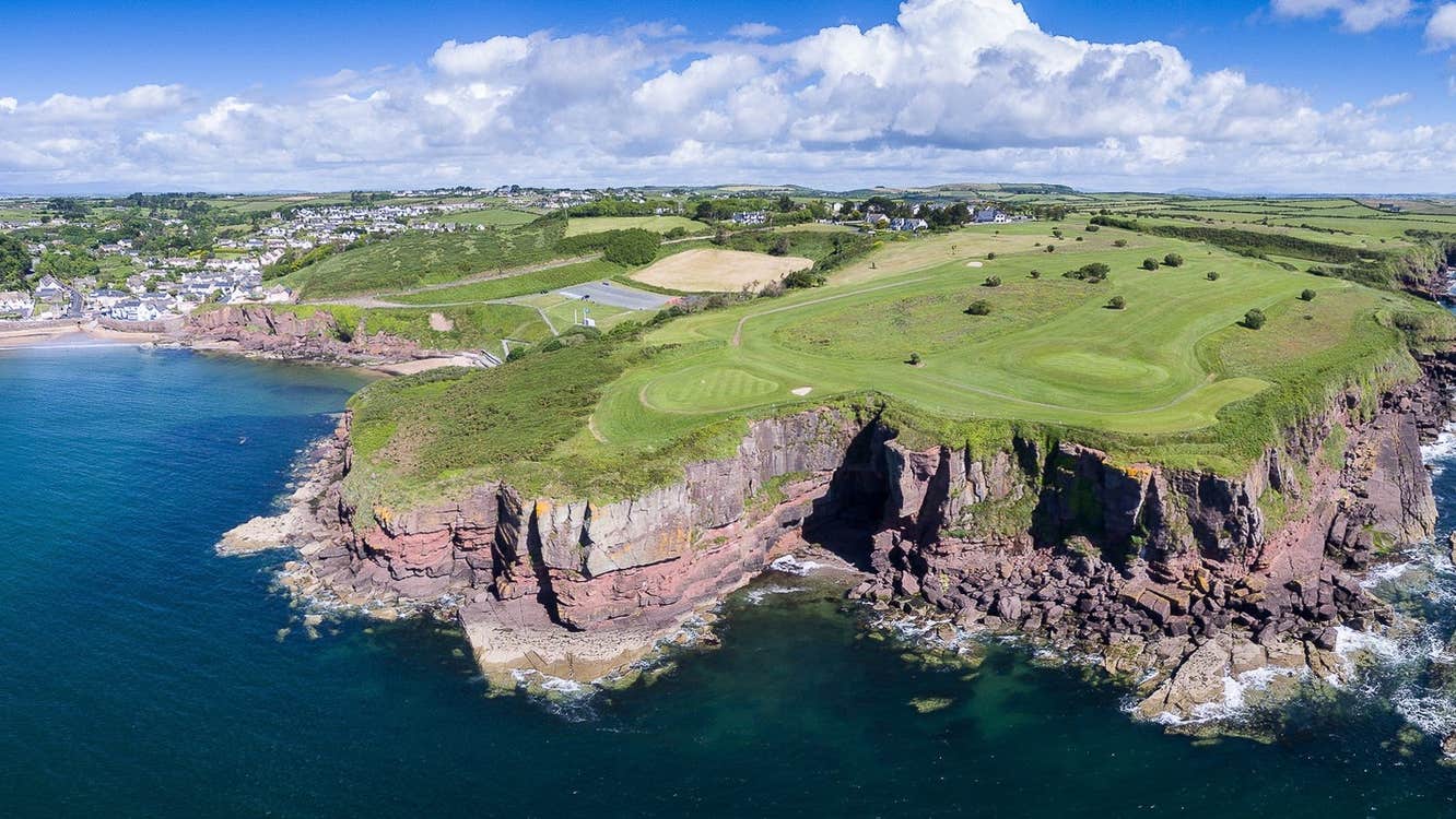 Golf course with cliffs the sea and a beach to the left