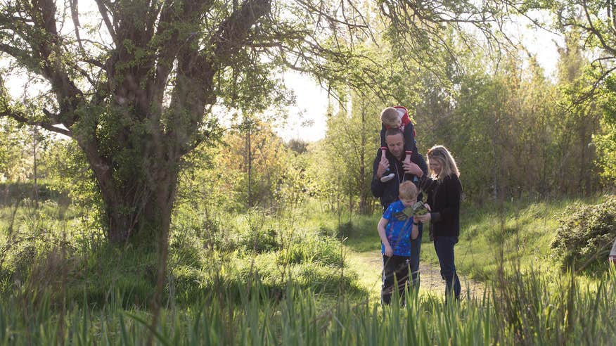 A family walking through Dún na Sí Amentity and Heritage Park in Westmeath.