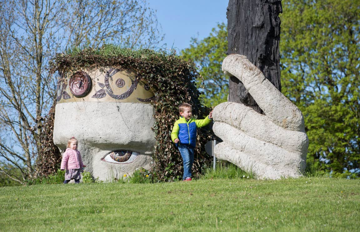 Two Kids playing at Dun na Si Westmeath beside some large sculptures
