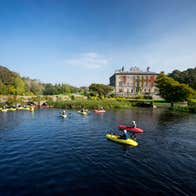 A group of people kayaking in front of Westport House, Mayo