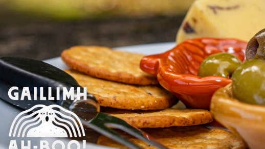 Féasta Fómhair / Harvest Feast, partial view of a platter of food including crackers, cheese and olives.
