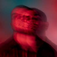 A very blurry headshot of a man in shades of red and black