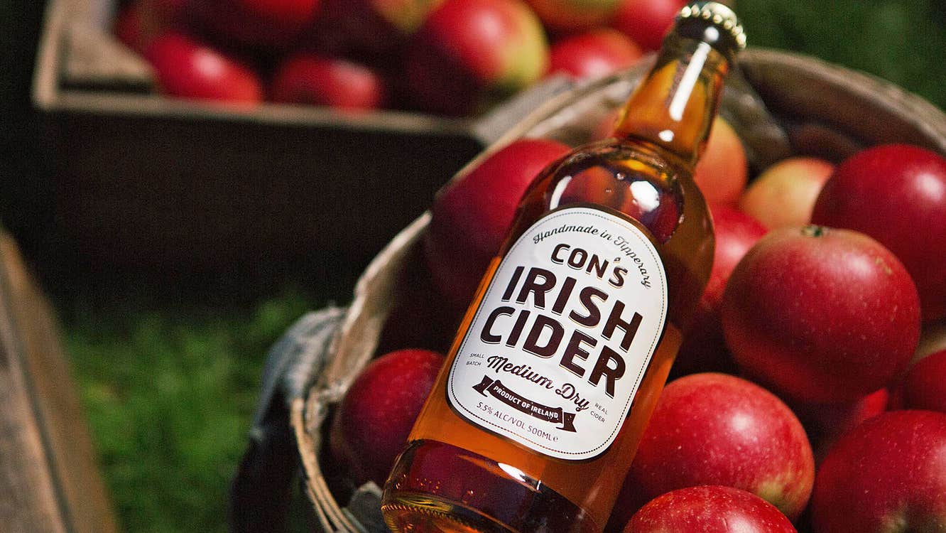 The Apple Farm view of a bottle of cider on a basket of red apples
