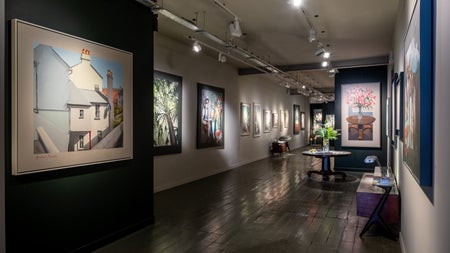 Interior of an art gallery with pictures on walls and subdued lighting
