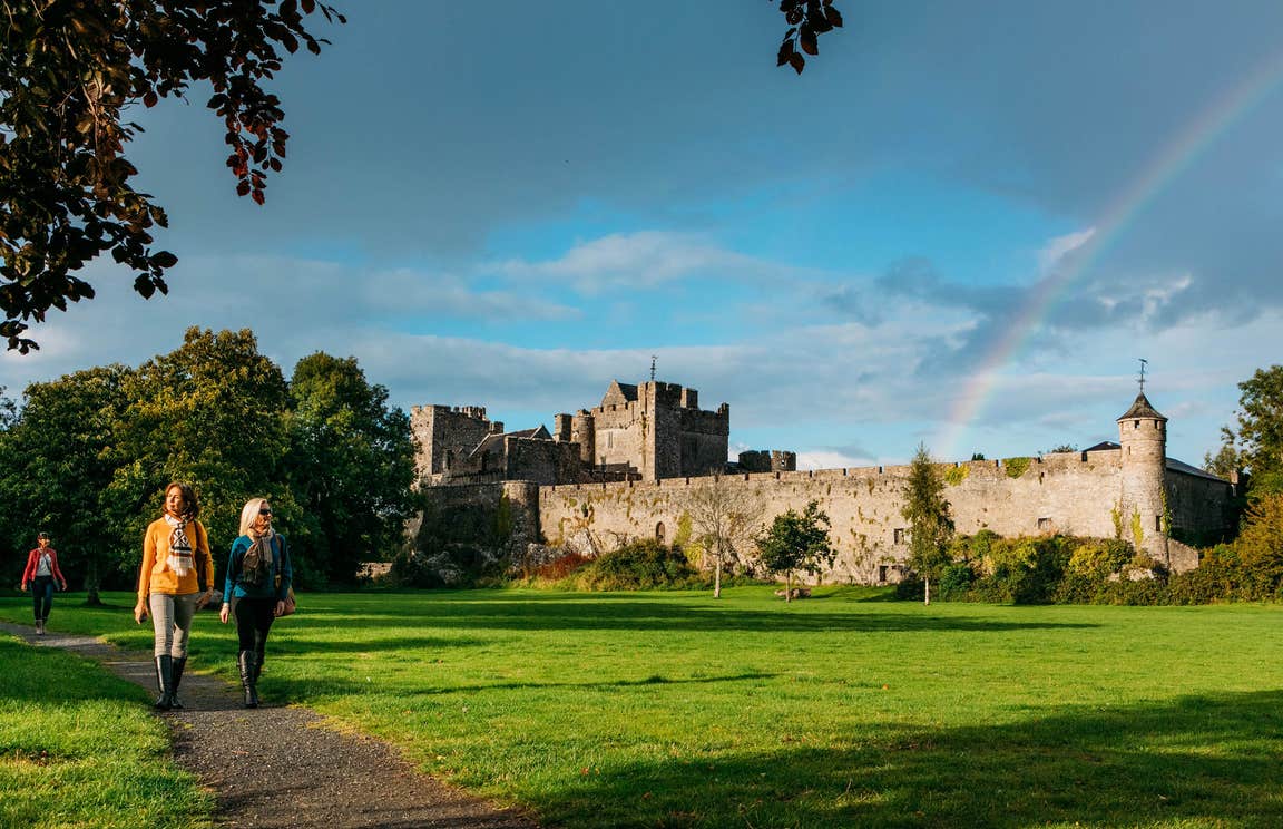 People walking on a path through a lawn outside Cahir Castle, Tipperary
