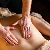 Massage therapist performing a back massage in a calm and relaxing therapy setting