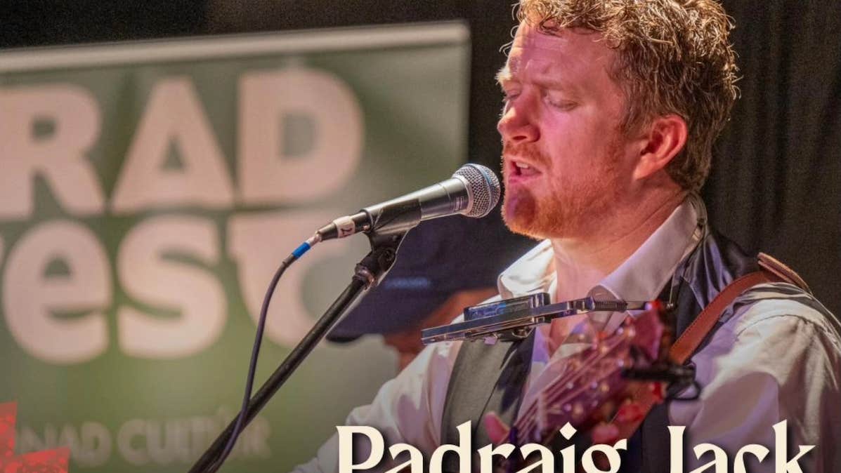 A man playing a guitar singing into a mic