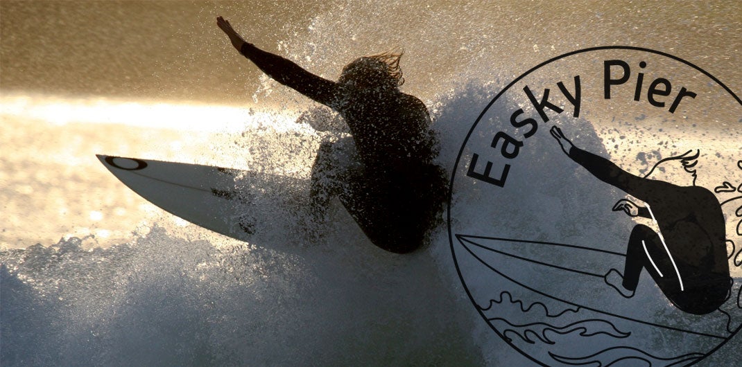 Surfer at sunset on Easkey Pier in County Sligo