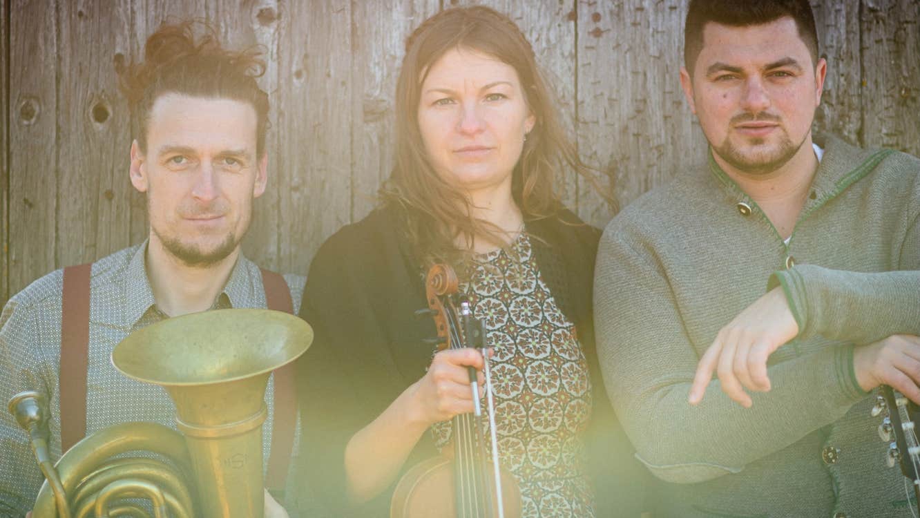 Slightly blurry photo of 3 musicians with instruments
