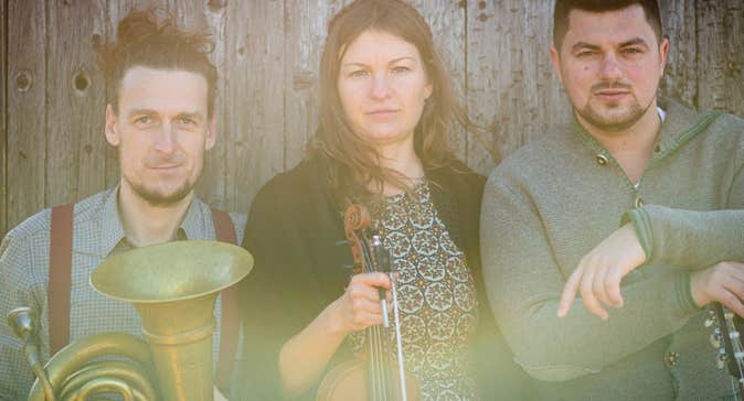 Slightly blurry photo of 3 musicians with instruments