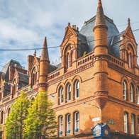 Historic red brick Victorian building with pointed turrets and arched windows