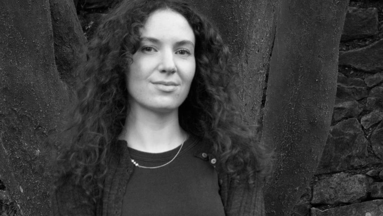 Síomha Callanan: Residency at Triskel Arts Centre, pictured standing in front of large tree trunks