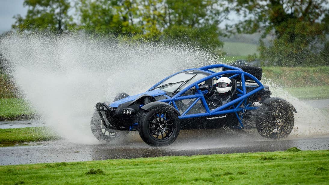 A rally driver in a blue car sending sprays of water up in the air at Rally School Ireland, Monaghan