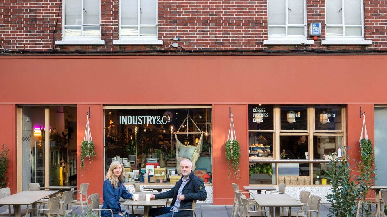 Exterior of a café with a couple sitting at an outdoor table
