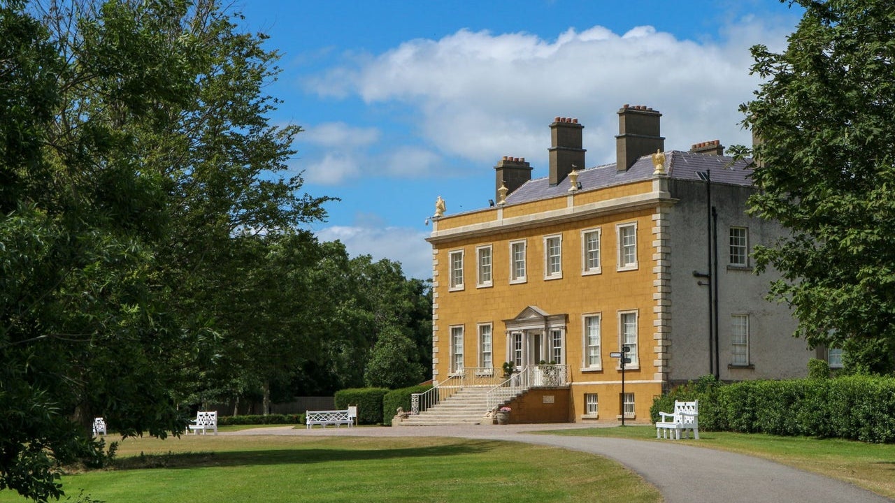 Exterior view of Newbridge House with trees and driveway