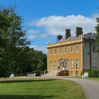 Exterior view of Newbridge House with trees and driveway