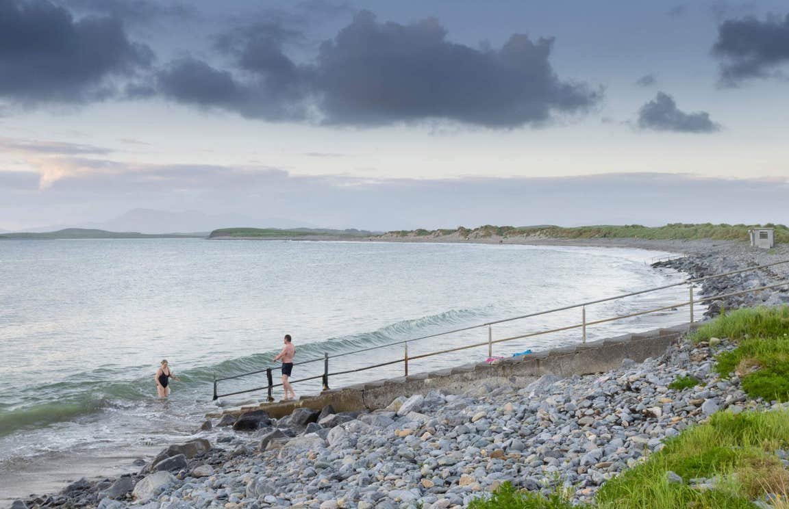 Two people getting into the Atlantic Ocean at Bertra Beach near WestPort in Mayo.