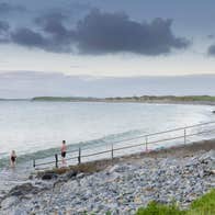 Two people getting into the Atlantic Ocean at Bertra Beach near WestPort in Mayo.