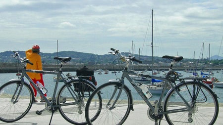 Irish Cycling Safaris view of bicycles next to a harbour with boats and hills in the background