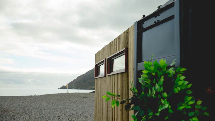 Fad Saoil Sauna on the beach in county Wicklow with a view of the water and expanse beyond.