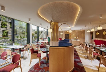 Red and wooden restaurant interior with tables and chairs on either side