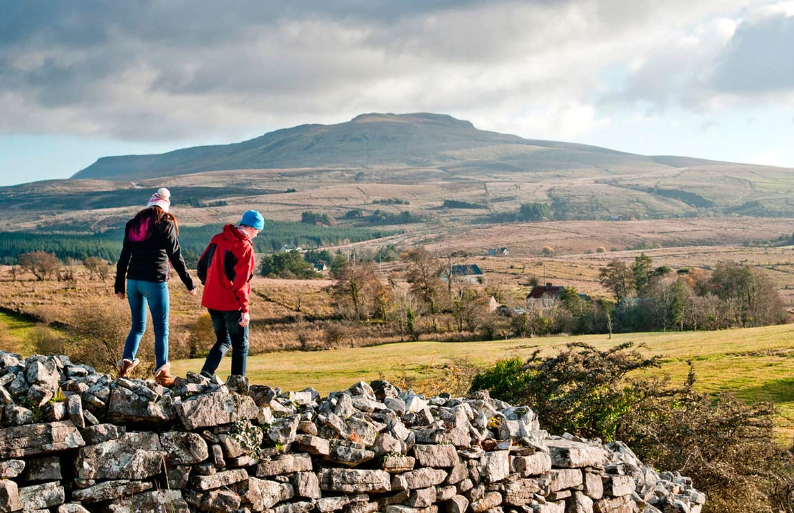 Two people walking on a stone wall in Cavan Burren Park, Cavan