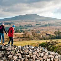 Two people walking on a stone wall in Cavan Burren Park, Cavan