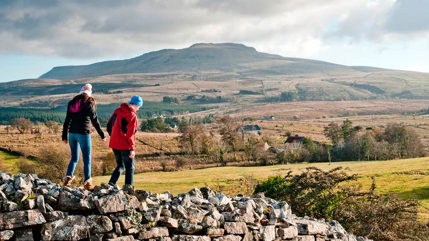 Two people walking on a stone wall in Cavan Burren Park, Cavan