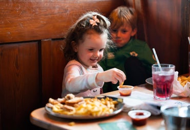 A girl eating chips and dip at Hogs & Heifers Bar & Grill Liffey Valley