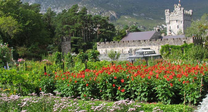 Glenveagh Castle surround by trees and colourful flowers