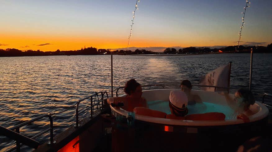 A group of friends enjoying a hot tub on The Hot Tub Boat