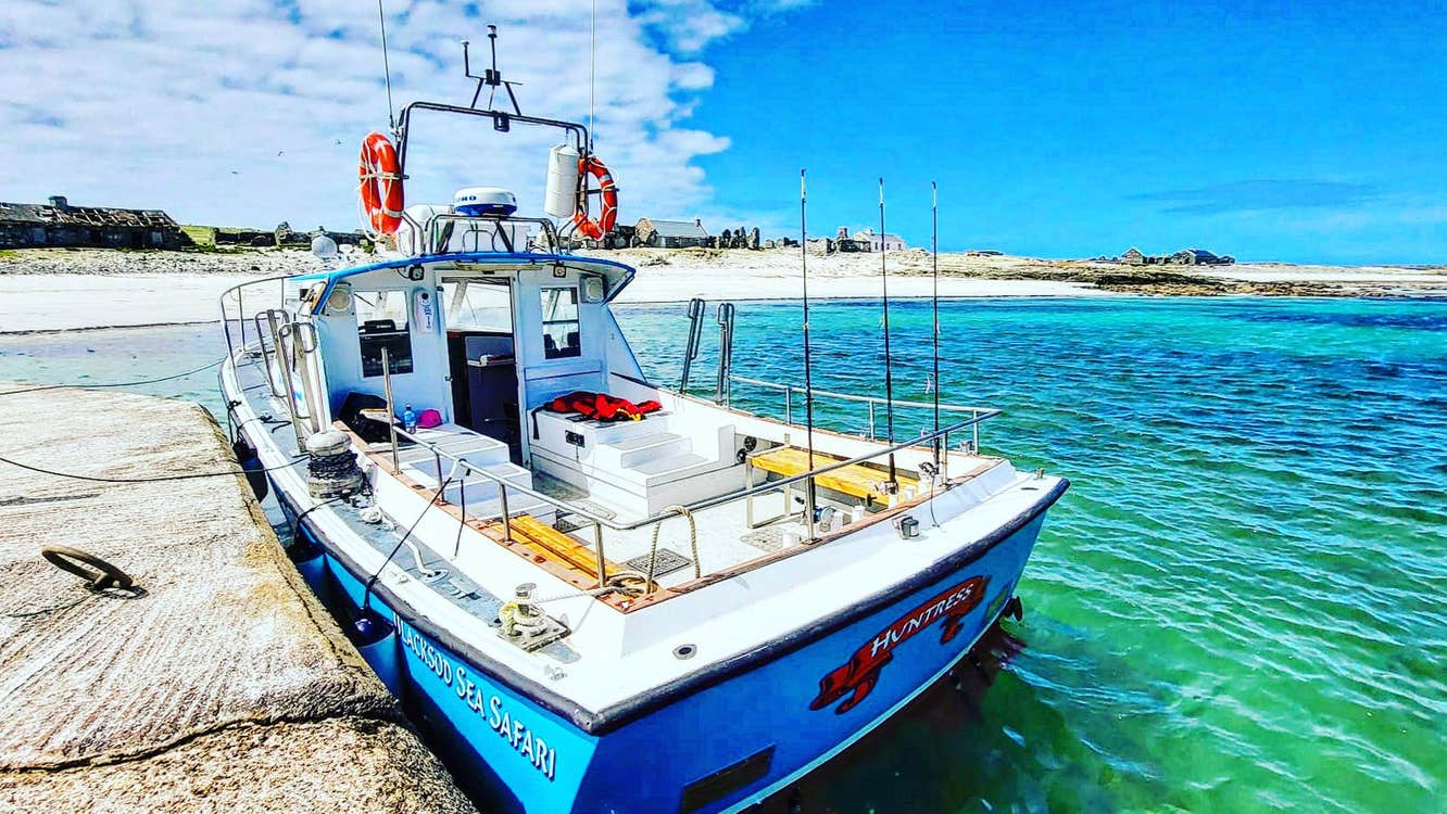 A boat moored at a pier on a clear blue sea