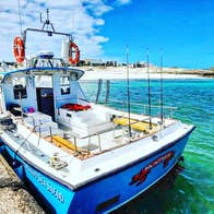 A boat moored at a pier on a clear blue sea