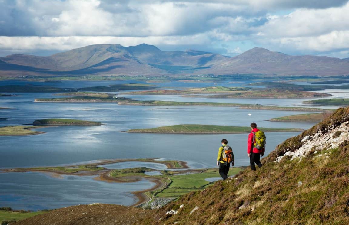 Two hikers on Croagh Patrick in Mayo near the waters of Clew Bay