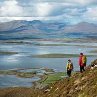 Two hikers on Croagh Patrick in Mayo near the waters of Clew Bay