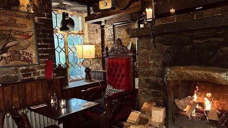 Interior of a pub with brick walls and old style décor beside a fire place