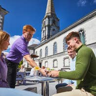 A waiter serving food to a table of three at the Bishop's Palace Café in Waterford city.