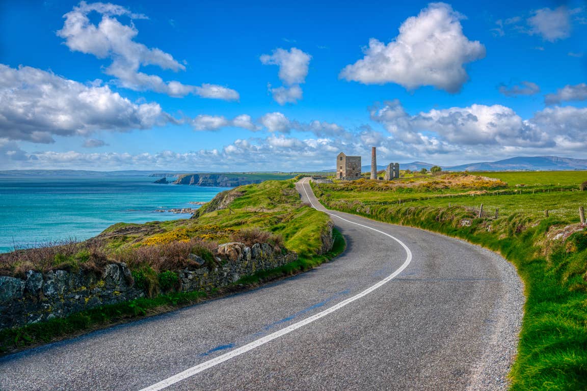 A country road beside a blue sea on the UNESCO Copper Coast, Waterford in Ireland's Ancient East.