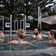 A group of people enjoying a cold plunge pool with The Hot Box Sauna Inchicore