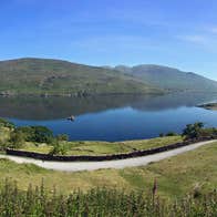 A view of killary fjord with mountains in background and green fields in the foreground