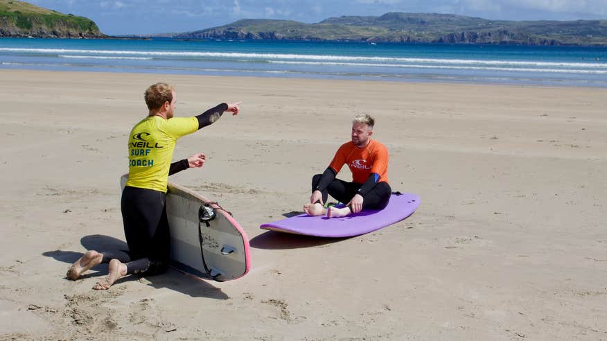 A man getting a surf lesson from Narosa Surf School in Dunfanaghy in County Donegal.