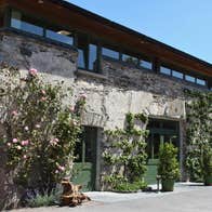 Converted barn with old style doors and ivy clad walls and potted plants at the doors