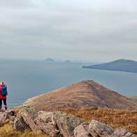 Two people taking a break while out hiking to look out at the sea view and Skellig Rock